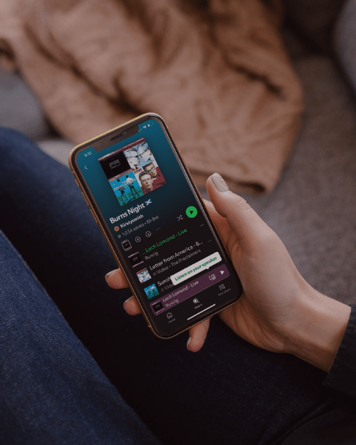 hand holding phone with spotify playlist 